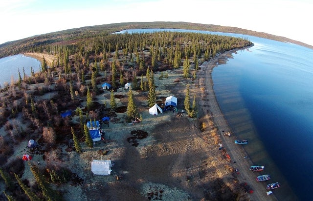Aerial view of this year's fish camp, showing its location on a point of land near the community of Wekweètì.  You can see boats lined up ready for sampling fish, water and lake sediments.  (Photo:  Paul Vecsei, Golder Associates Ltd.)