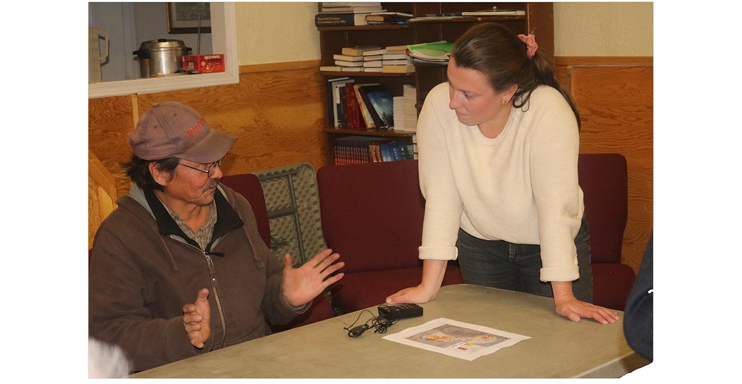 WRRB Conservation Biologist Aimee Guile consults with Bobby Lafferty during a presentation on tǫdzı (boreal caribou) in Behchokǫ̀, Oct. 12. 