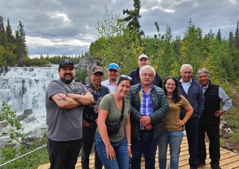 Nàı̨lı̨ı̨ (Whatı̀ Falls): Starting from the far  left, is Travis Washie, followed by Eddie Chocolate, Tom Lafferty, and Stu Niven. From the center, standing front row, is Amanda Weltman, followed by Jonas Lafferty, Laura Meinert, James Rabesca, and Joseph Judas.