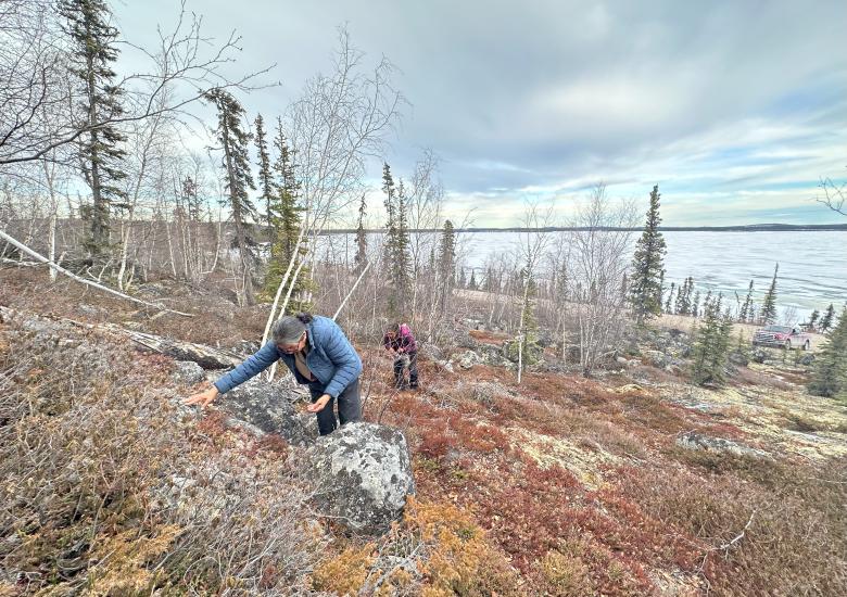 Mary Adele Football and Violet Mackenzie pick last year’s  Įtł'ǫ̀ (cranberries) in Wekweètìi in May.  Aimee Guile/WRRB  