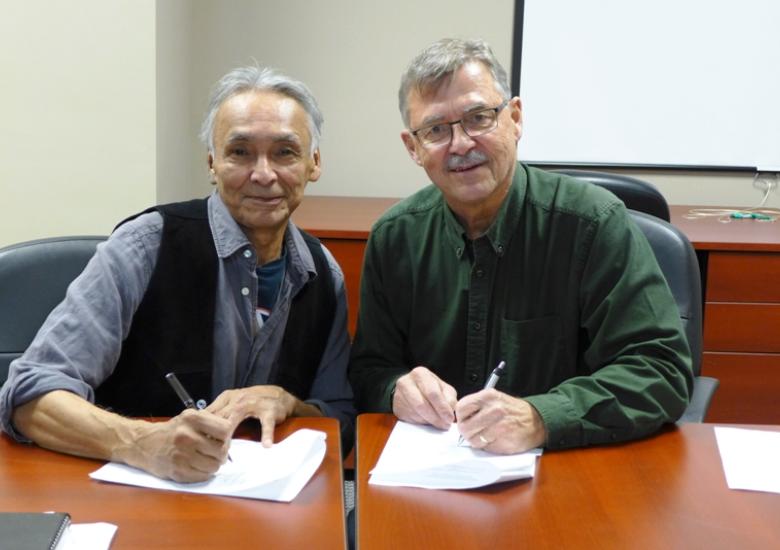 SRRB Chair Michael Neyelle and WRRB Special Representative Grant Pryznyk sign MOU on Bluenose-East Caribou herd  [Photo: Susan Beaumont, WRRB]